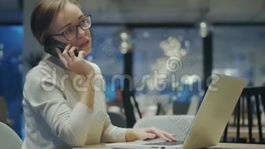 年轻女子坐在咖啡馆里用<strong>手机接电话</strong>